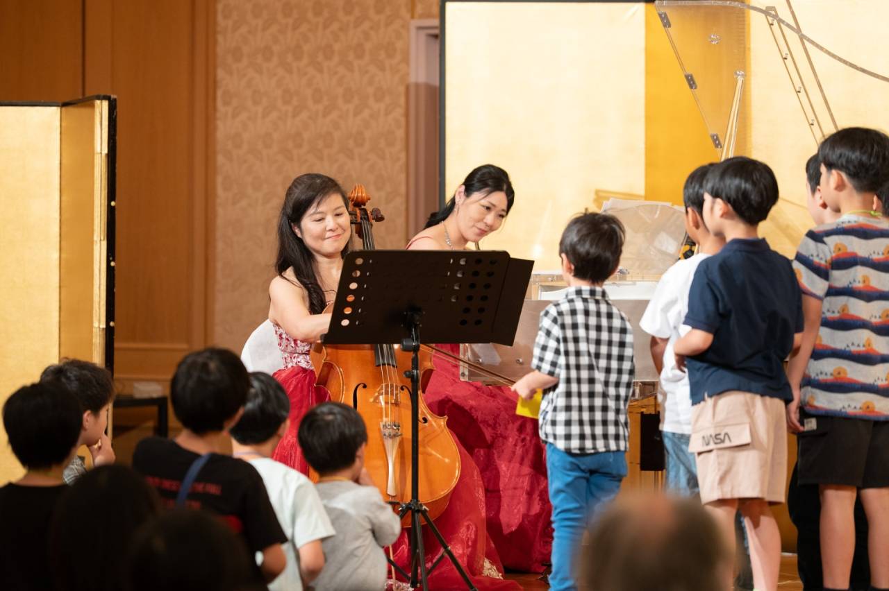 チェロの演奏を子どもたちが至近距離で聴いている様子
